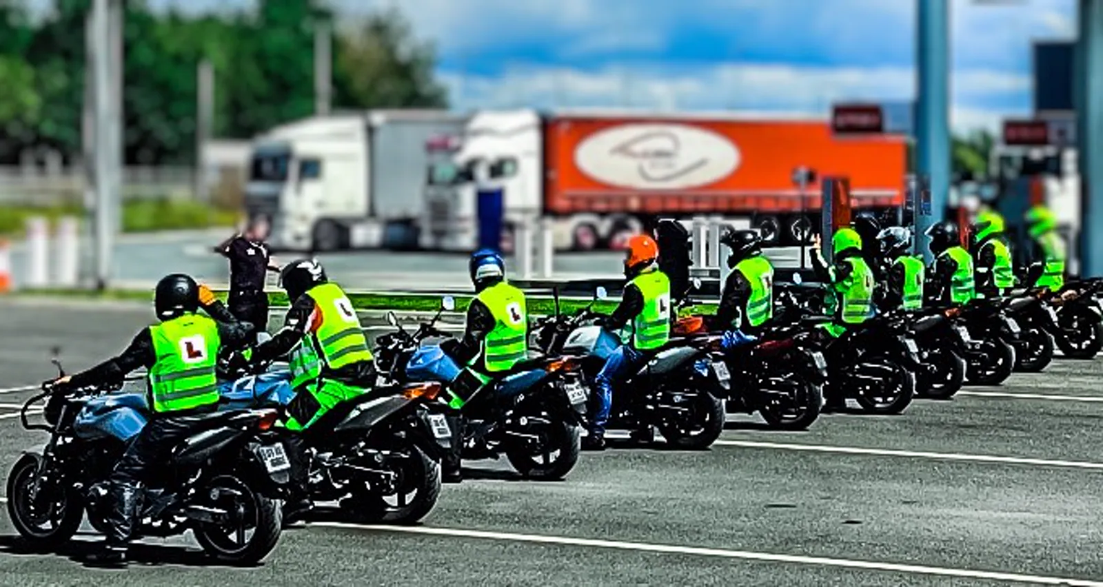 A full IBT class lined up on motorcycles in hi-vis L-plate vests at a O'Neill Motorcycle Training training ground